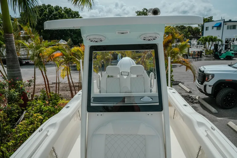 Slide: The Image of 2026 Key West 239 FSR boat with sleek design, parked near tropical foliage. - 32