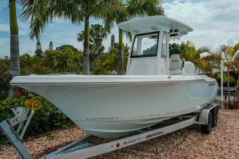 Slide: The Image of 2026 Key West 239 FSR boat on trailer, surrounded by tropical palm trees. - 4
