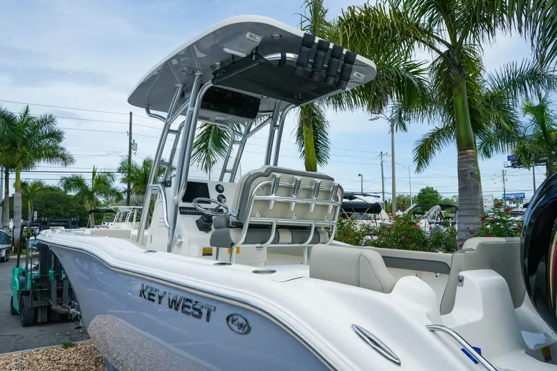 Slide: The Image of 2026 Key West 239 FS boat with T-top, docked near palm trees. - 10