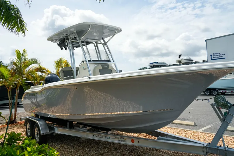 Slide: The Image of 2026 Key West 239 FS boat on trailer, parked outdoors near palm trees. - 5