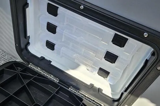 Slide: The Image of Storage compartment in 2026 Bennington 22 SF boat, featuring organized tackle boxes. - 13