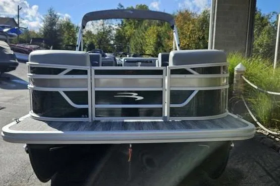 Slide: The Image of 2026 Bennington 22 SF pontoon boat, rear view, parked outdoors on a sunny day. - 2