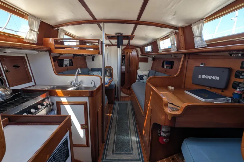 Slide: The Image of Interior of 1984 Ohlson 38 sailboat with wooden cabinetry and modern navigation equipment. - 10