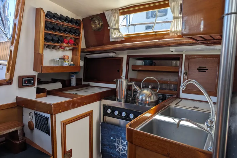 Slide: The Image of 1984 Ohlson 38 yacht kitchen with wooden cabinetry, spice rack, and stainless steel sink. - 12