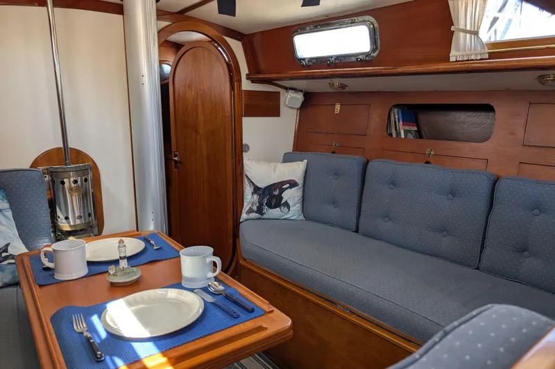 Slide: The Image of Cozy interior of 1984 Ohlson 38 sailboat with dining area and blue upholstery. - 13