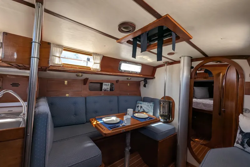Slide: The Image of Cozy interior of a 1984 Ohlson 38 sailboat with dining area and wooden finishes. - 15