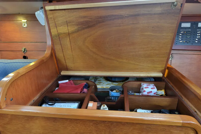 Slide: The Image of Wooden storage compartment on 1984 Ohlson 38 yacht, containing various items and equipment. - 21