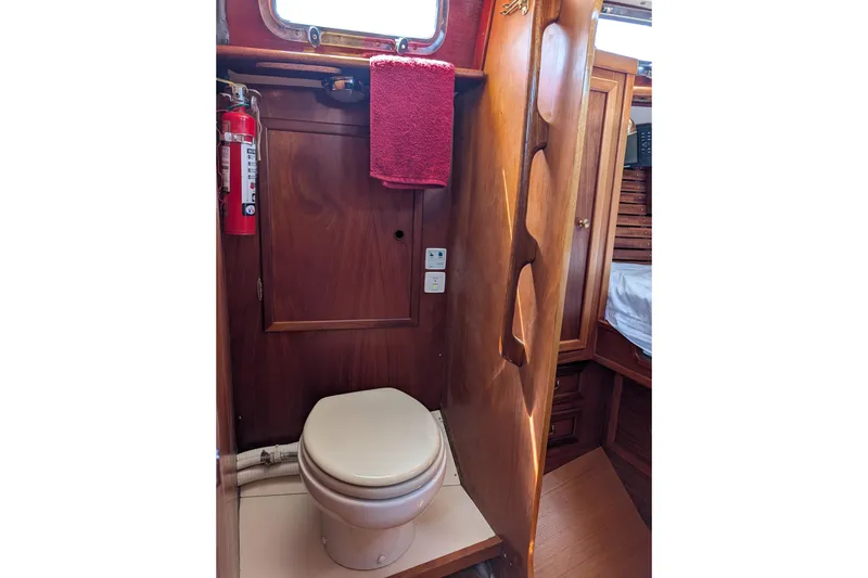 Slide: The Image of 1984 Ohlson 38 yacht bathroom with wooden interior, toilet, and fire extinguisher. - 24