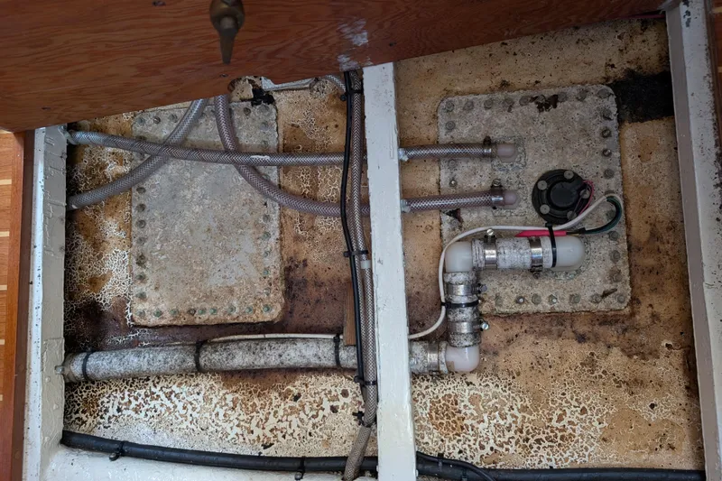 Slide: The Image of Bilge area of a 1984 Ohlson 38 sailboat with visible plumbing and wiring. - 27