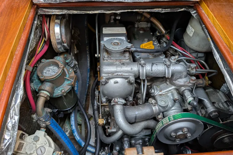 Slide: The Image of Engine compartment of a 1984 Ohlson 38 sailboat, showcasing mechanical components and wiring. - 28