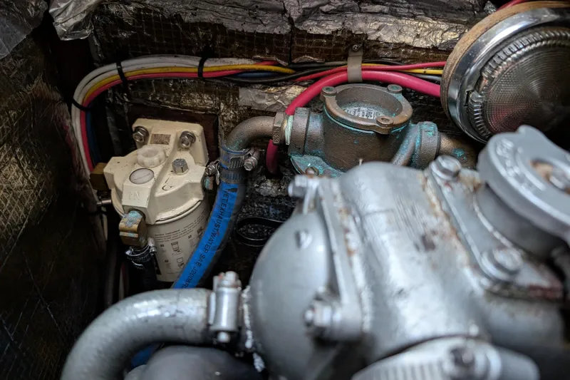 Slide: The Image of Engine compartment of a 1984 Ohlson 38 sailboat, showing mechanical components and wiring. - 30
