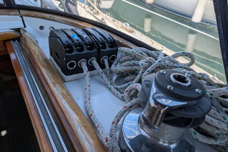 Slide: The Image of Close-up of sailing equipment on a 1984 Ohlson 38 yacht, featuring ropes and winch. - 33