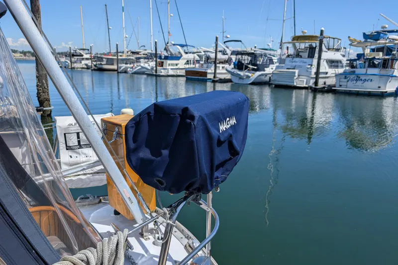 Slide: The Image of Ohlson 38 sailboat from 1984 docked at a marina with covered equipment. - 45