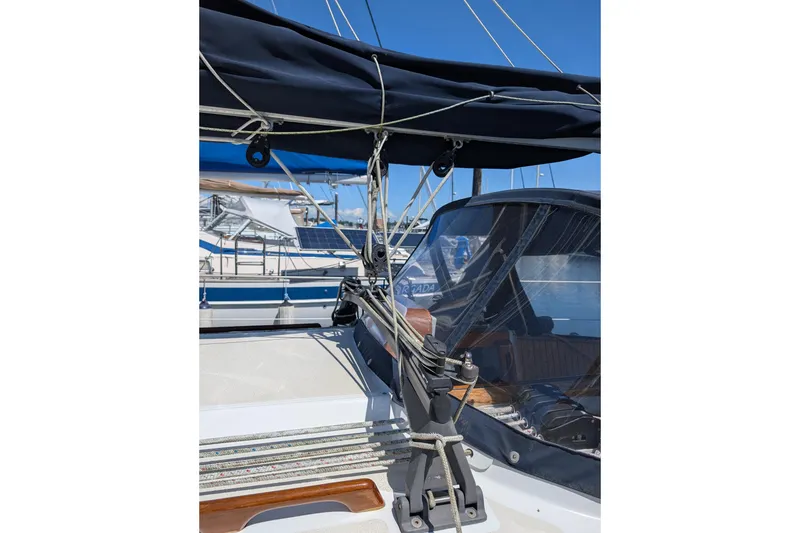 Slide: The Image of 1984 Ohlson 38 sailboat deck with rigging and canopy under clear blue sky. - 47