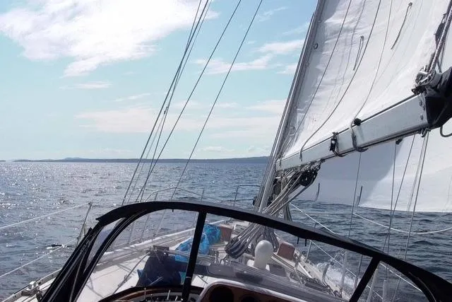 Slide: The Image of Sailing on a 1984 Ohlson 38 yacht with clear skies and calm waters. - 53