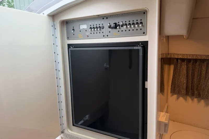 Slide: The Image of Control panel and refrigerator inside a 2002 Formula 330 Sun Sport boat cabin. - 23