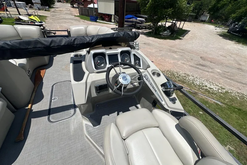 Slide: The Image of 2017 Manitou 25 SES boat interior with steering wheel and control panel. - 6