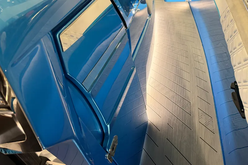 Slide: The Image of Interior view of 2028 Nor-Tech 42 Eleven boat, featuring sleek blue design and textured flooring. - 13