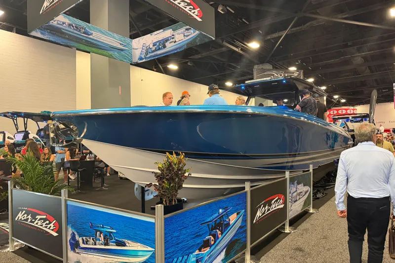 Slide: The Image of 2028 Nor-Tech 42 Eleven boat showcased at an indoor event, surrounded by attendees. - 3