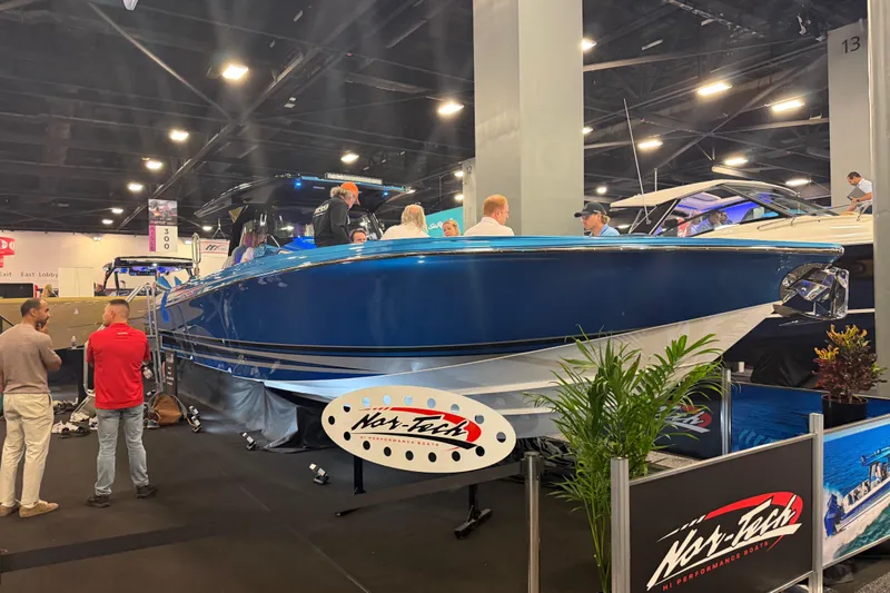 Slide: The Image of 2028 Nor-Tech 42 Eleven boat displayed at an indoor exhibition, surrounded by people. - 4