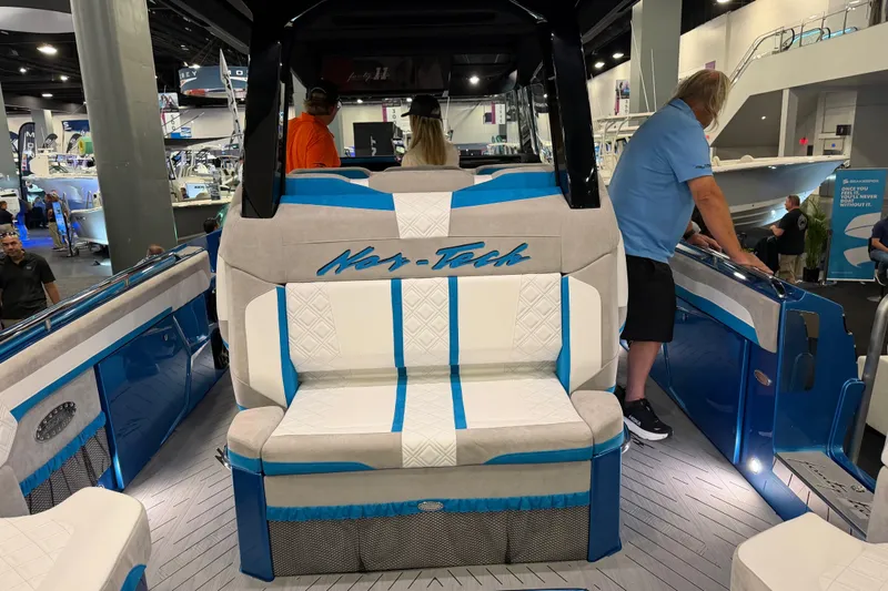 Slide: The Image of 2028 Nor-Tech 42 Eleven boat interior with blue and white seating at a boat show. - 9