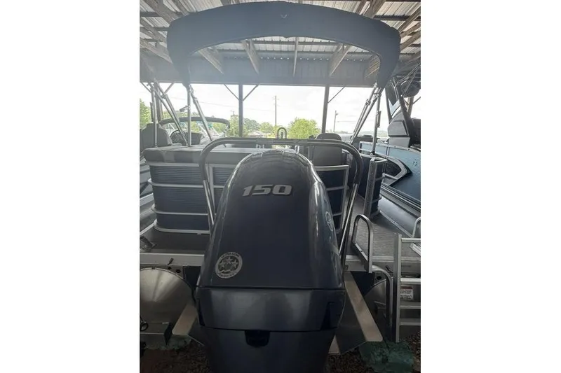 Slide: The Image of 2022 Bennington 22 SLX pontoon boat with 150 HP engine under a covered dock. - 3