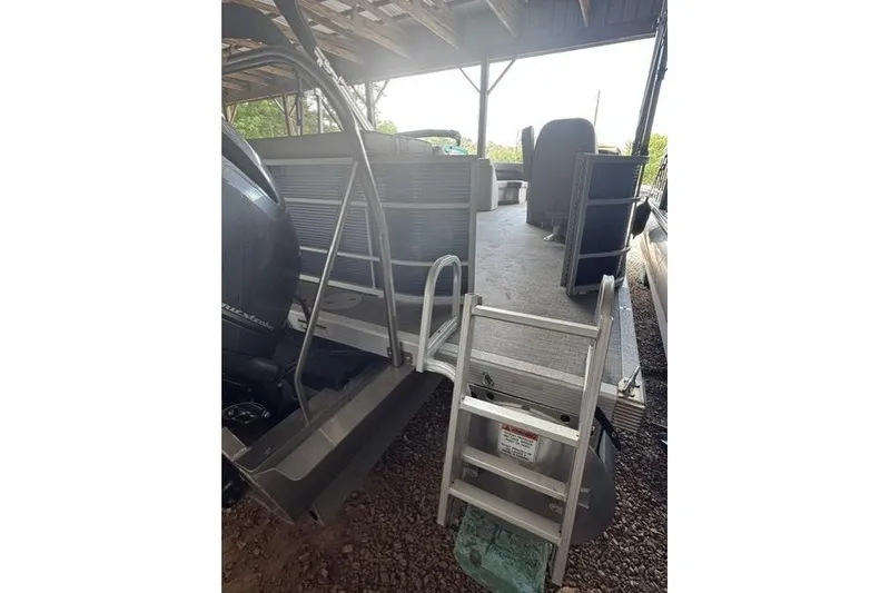 Slide: The Image of 2022 Bennington 22 SLX pontoon boat with ladder, under covered storage. - 4