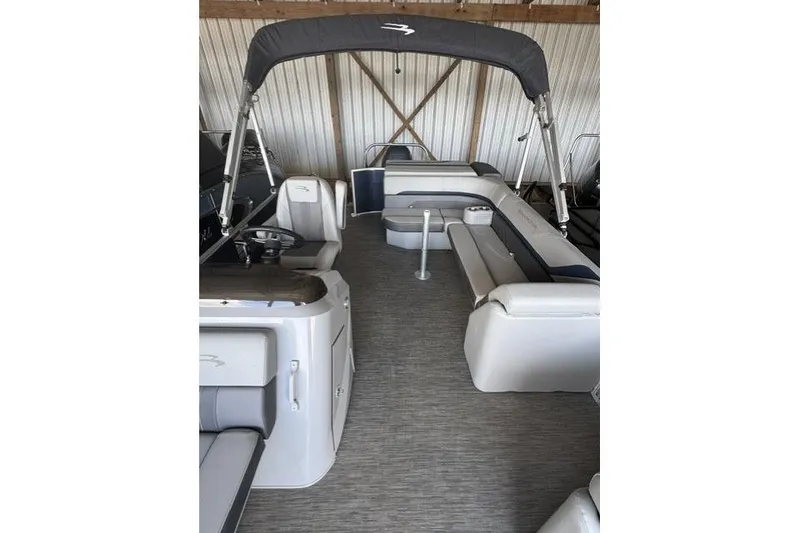 Slide: The Image of 2022 Bennington 22 SLX pontoon boat interior with seating and canopy in storage. - 9
