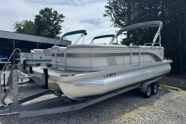 Slide: The Image of 2021 Bennington 24 LRSC pontoon boat on trailer, parked outdoors. - 13