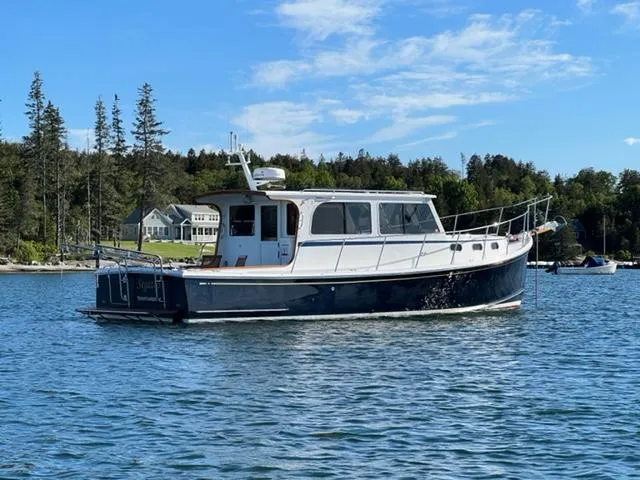 Slide: The Image of 2000 Duffy 35 Hardtop Cruiser on calm water with coastal backdrop. - 1