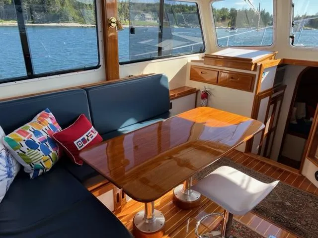 Slide: The Image of Interior of 2000 Duffy 35 Hardtop Cruiser with wooden table and blue cushions. - 3