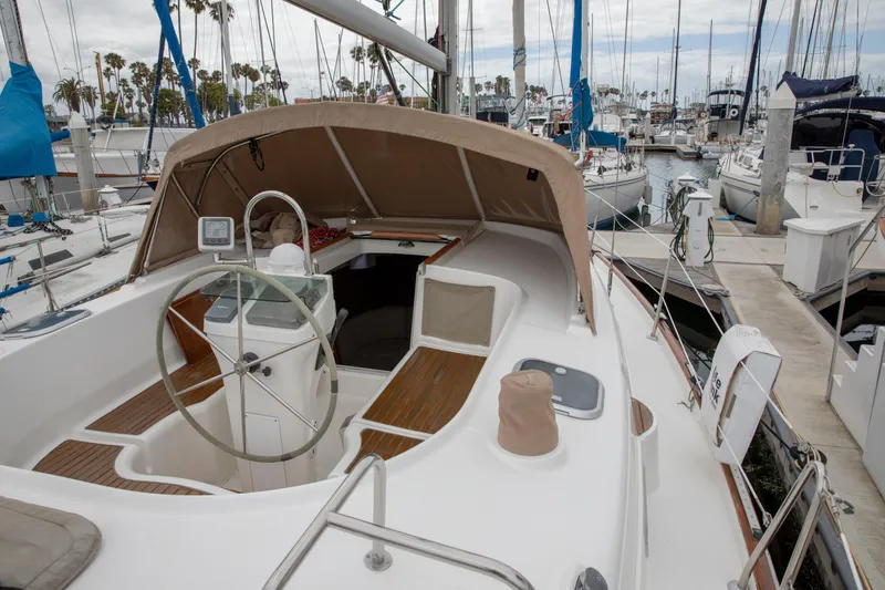 Slide: The Image of 1999 Beneteau Oceanis 36 CC sailboat docked in marina, featuring spacious cockpit and helm. - 16