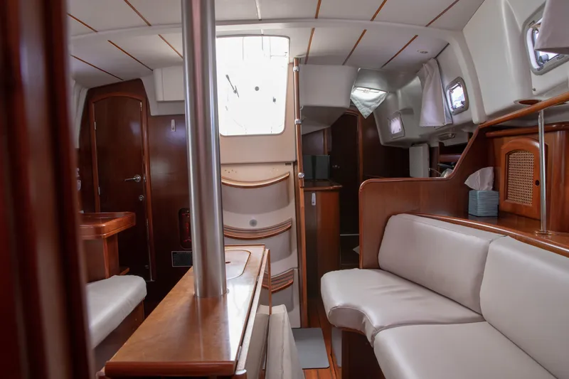 Slide: The Image of Interior of 1999 Beneteau Oceanis 36 CC sailboat, featuring elegant wood finishes and comfortable seating. - 24