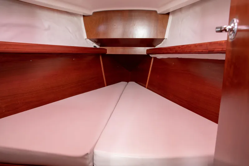 Slide: The Image of Interior cabin of 1999 Beneteau Oceanis 36 CC with wooden finish and cushioned berth. - 25