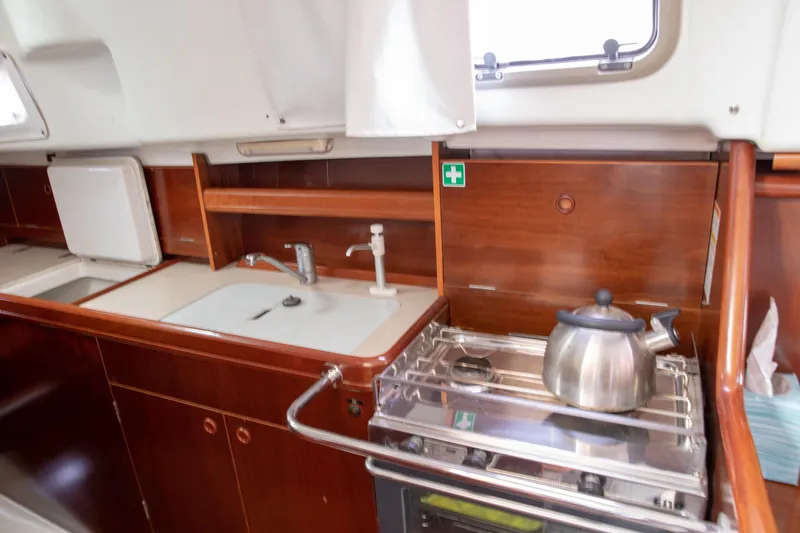 Slide: The Image of Galley of 1999 Beneteau Oceanis 36 CC with stove, sink, and kettle. - 33