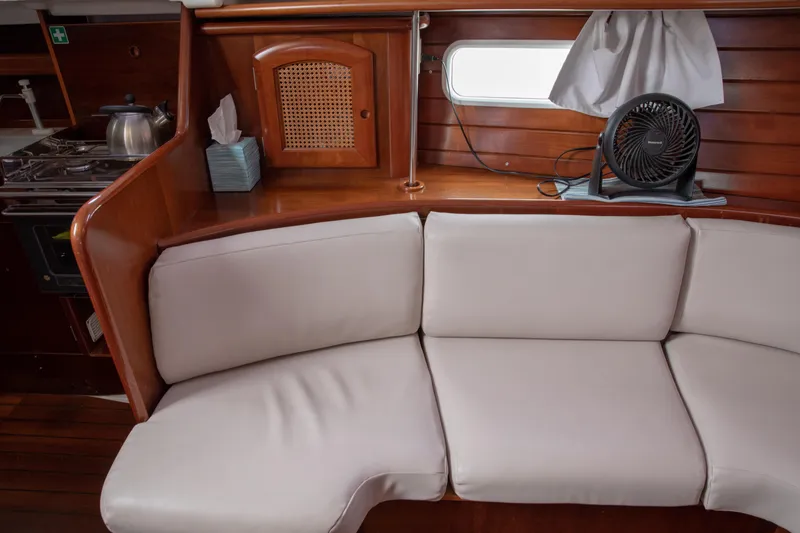 Slide: The Image of Interior of 1999 Beneteau Oceanis 36 CC yacht with cozy seating and wooden accents. - 40