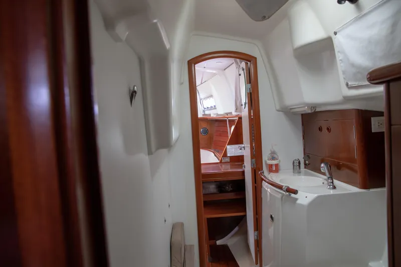 Slide: The Image of Interior of 1999 Beneteau Oceanis 36 CC sailboat, featuring a compact bathroom and wooden cabinetry. - 46