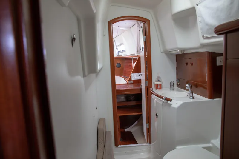 Slide: The Image of Interior of 1999 Beneteau Oceanis 36 CC sailboat, featuring a compact bathroom and wooden cabinetry. - 47
