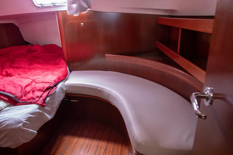 Slide: The Image of Cozy cabin interior of 1999 Beneteau Oceanis 36 CC with wooden finish and red bedding. - 53