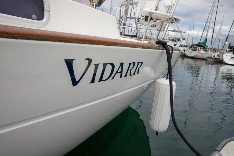 Slide: The Image of Beneteau Oceanis 36 CC sailboat docked, featuring "VIDARR" name on hull, 1999 model. - 55