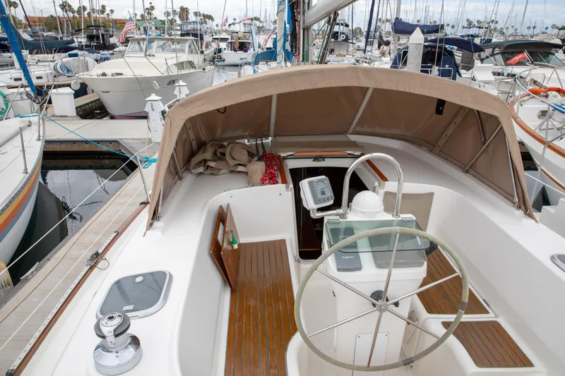 Slide: The Image of 1999 Beneteau Oceanis 36 CC sailboat cockpit with steering wheel, docked at marina. - 8