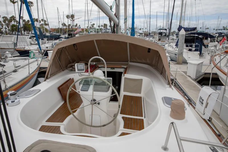 Slide: The Image of 1999 Beneteau Oceanis 36 CC sailboat cockpit with steering wheel, docked at marina. - 9