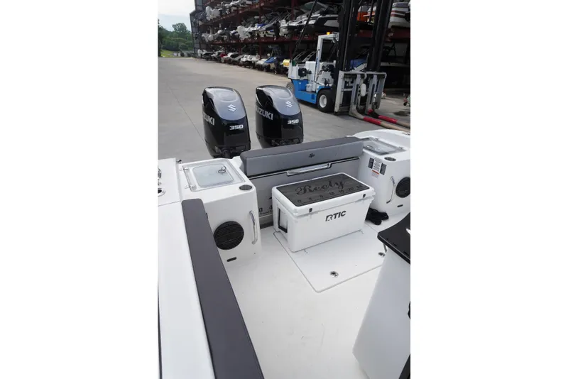 Slide: The Image of 2025 Sea Pro 292 DLX boat with Suzuki 350 engines and RTIC cooler on deck. - 12