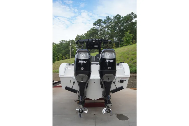 Slide: The Image of 2025 Sea Pro 292 DLX boat with dual Suzuki 350 outboard engines, parked outdoors. - 6
