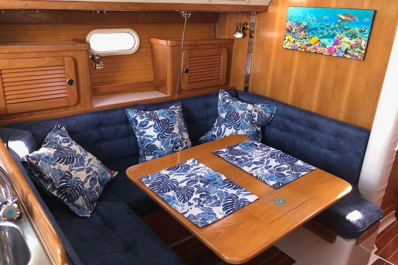 Slide: The Image of Cozy Catalina 36 MkII 2000 sailboat interior with blue cushions and tropical decor. - 2