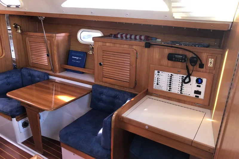 Slide: The Image of Interior of 2000 Catalina 36 MkII sailboat with wooden cabinetry and blue seating. - 3