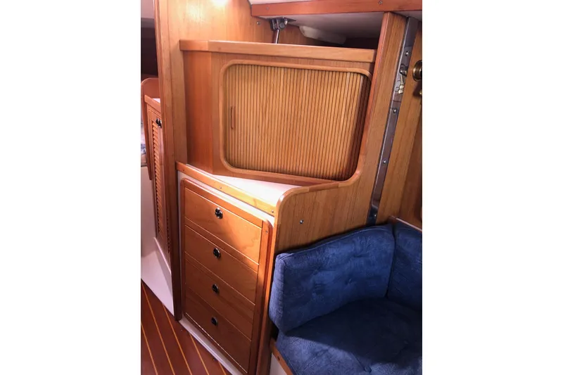 Slide: The Image of Interior of 2000 Catalina 36 MkII sailboat with wooden cabinetry and blue seating. - 6