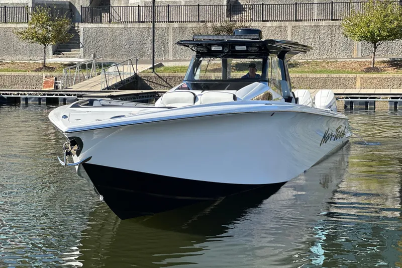 Slide: The Image of 2025 Nor-Tech 450 Sport Center Console boat docked in calm waters. - 9