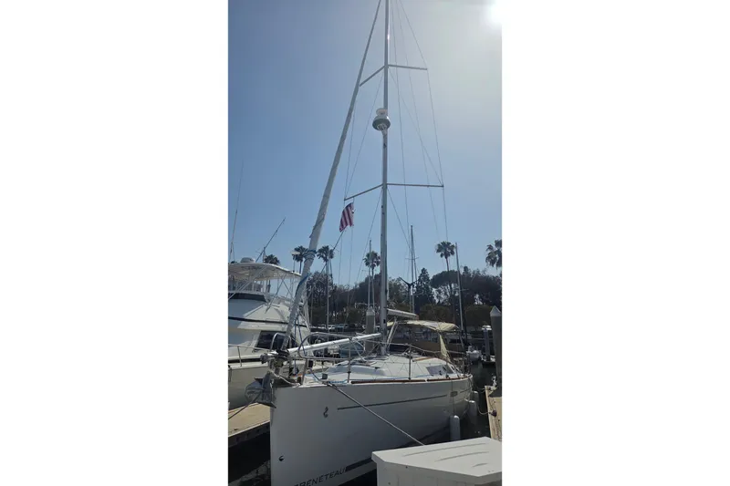 Slide: The Image of 2010 Beneteau Oceanis 37 sailboat docked under clear sky with palm trees. - 1