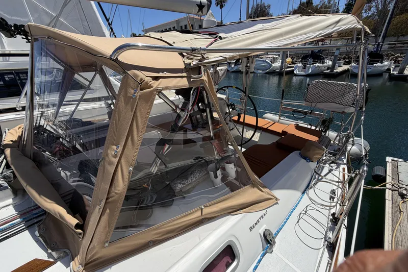 Slide: The Image of 2010 Beneteau Oceanis 37 sailboat with tan canopy docked in marina. - 19